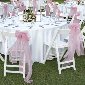 Pink Chair Sash on white resin chair at a wedding