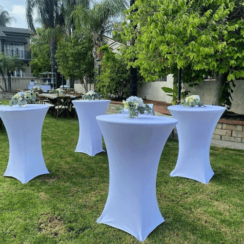 Cocktail tables at backyard party with white spandex covers